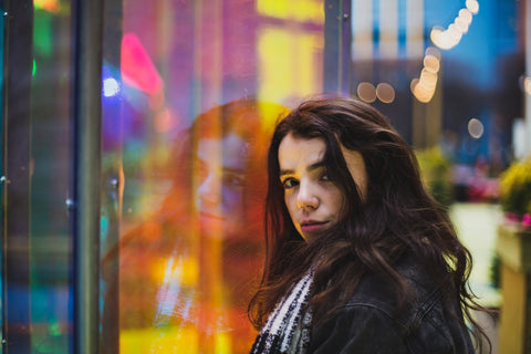 woman in black leather jacket standing near glass window