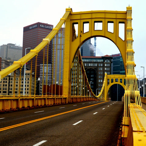 a large yellow bridge spanning a city street