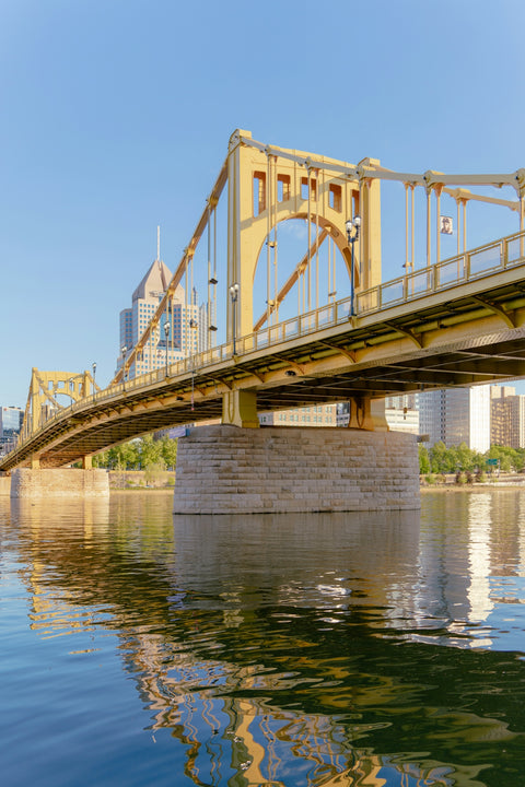 A bridge over a body of water with buildings in the background