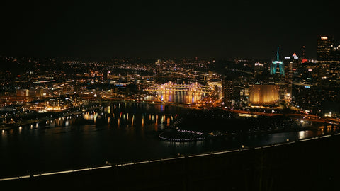 City lights shine brightly over the water at night.