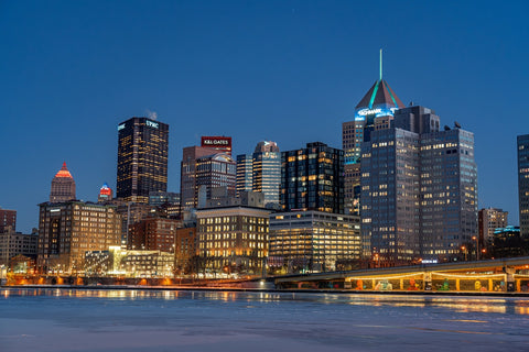 City skyline lights up at dusk.