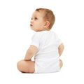 Back view of baby in white onesie, showing fit and comfort of infant jersey one piece for daily use.