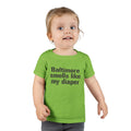 Toddler wearing green T-shirt with 'Baltimore smells like my diaper' print, a playful kids clothing choice.