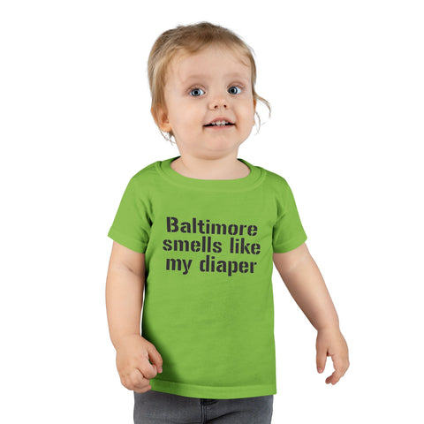 Toddler wearing green T-shirt with 'Baltimore smells like my diaper' print, a playful kids clothing choice.