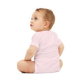 Back view of baby in pink onesie, showcasing comfort and stretch of infant jersey one piece.