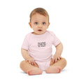 Baby in light pink onesie with 'Cleveland smells like my diaper' slogan, adorable and cheeky babywear.