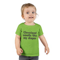 Toddler wearing green T-shirt with funny black text 'Cleveland smells like my diaper,' ideal for humorous kids outfits.