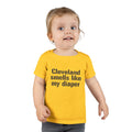 Toddler in yellow T-shirt with bold black text 'Cleveland smells like my diaper,' perfect for playful kids fashion.