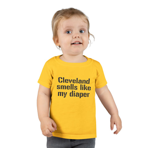 Toddler in yellow T-shirt with bold black text 'Cleveland smells like my diaper,' perfect for playful kids fashion.