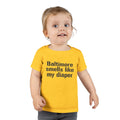 Toddler in yellow T-shirt with 'Baltimore smells like my diaper' slogan, a humorous and bold kidswear option.