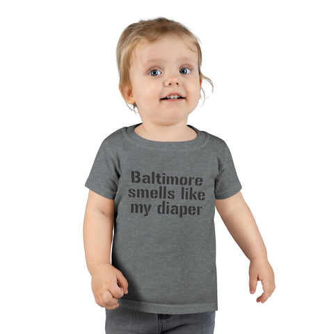 Toddler in dark gray T-shirt with 'Baltimore smells like my diaper' slogan, a cheeky and fun kids fashion item.