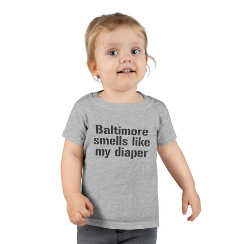 Toddler wearing gray T-shirt with 'Baltimore smells like my diaper' text, showcasing a funny kids fashion piece.