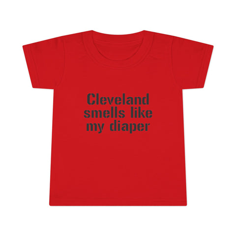 Red toddler T-shirt with bold black text 'Cleveland smells like my diaper,' a funny and eye-catching kidswear item.