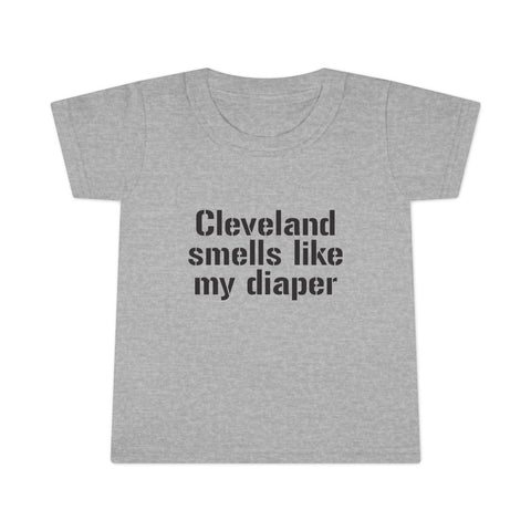 Gray toddler T-shirt with bold black text reading 'Cleveland smells like my diaper' in a humorous design for kids clothes.