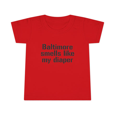 Red toddler T-shirt with black 'Baltimore smells like my diaper' slogan, a humorous and eye-catching kidswear design.